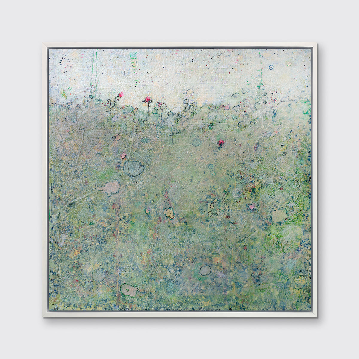 A green abstract landscape print in a white floater frame hangs on a white wall.