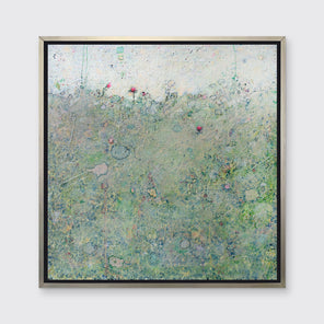 A green abstract landscape print in a silver floater frame hangs on a white wall.