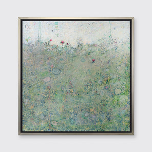 A green abstract landscape print in a silver floater frame hangs on a white wall.