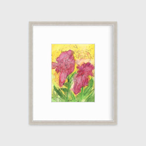 A red, yellow, green and black abstract floral print in a silver frame with a mat hangs on a white wall.