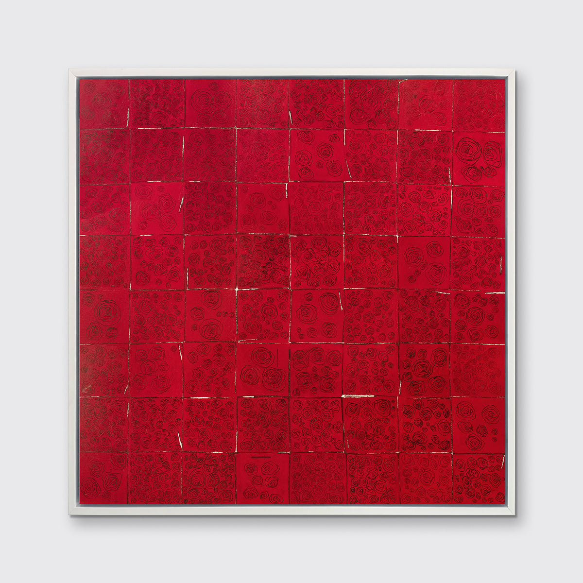 A red and black abstract geometric print in a white floater frame hangs on a white wall.