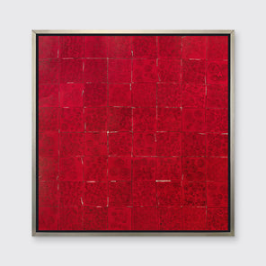 A red and black abstract geometric print in a silver floater frame hangs on a white wall.