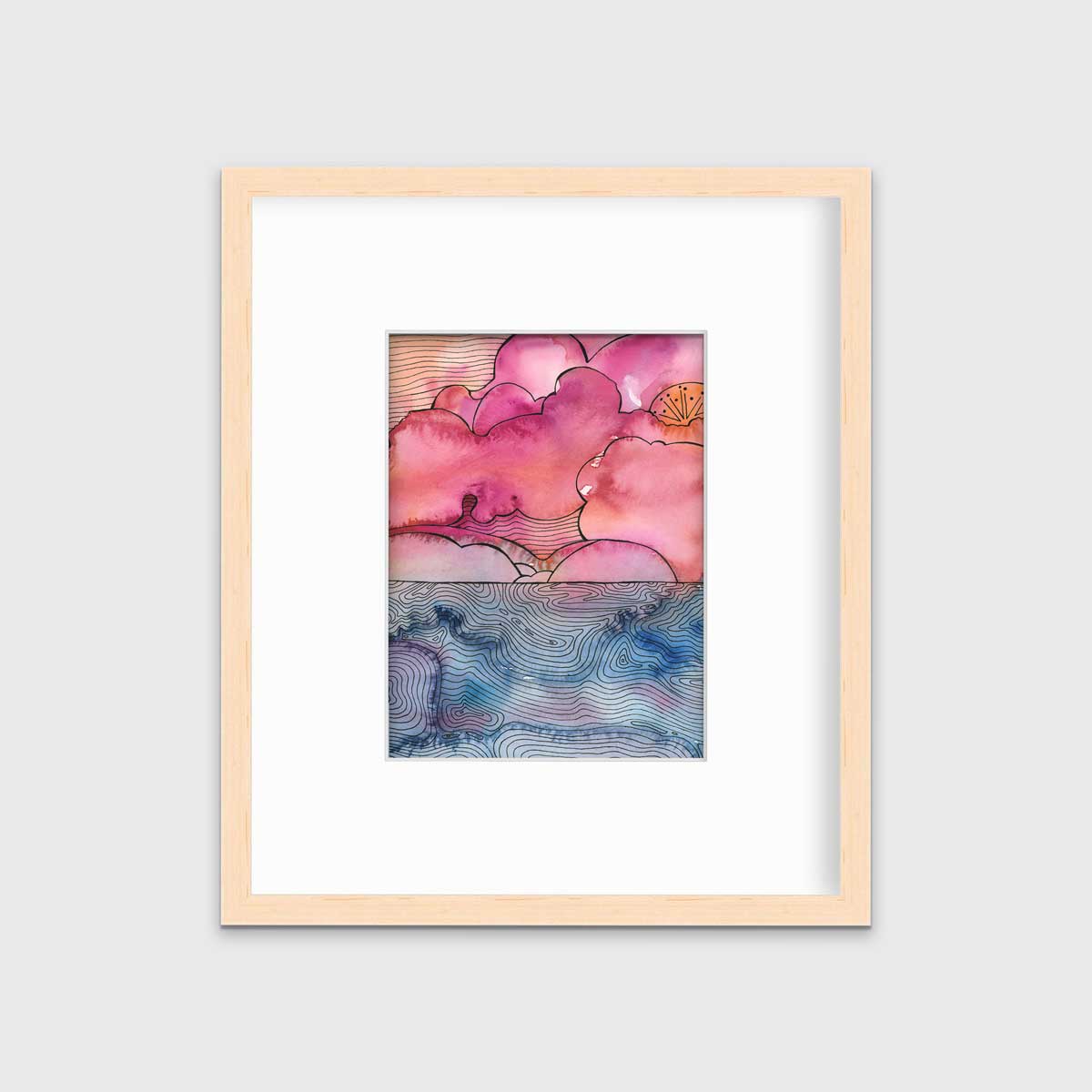 A pink, blue and black abstract landscape print in a natural wood frame with a mat hangs on a white wall.