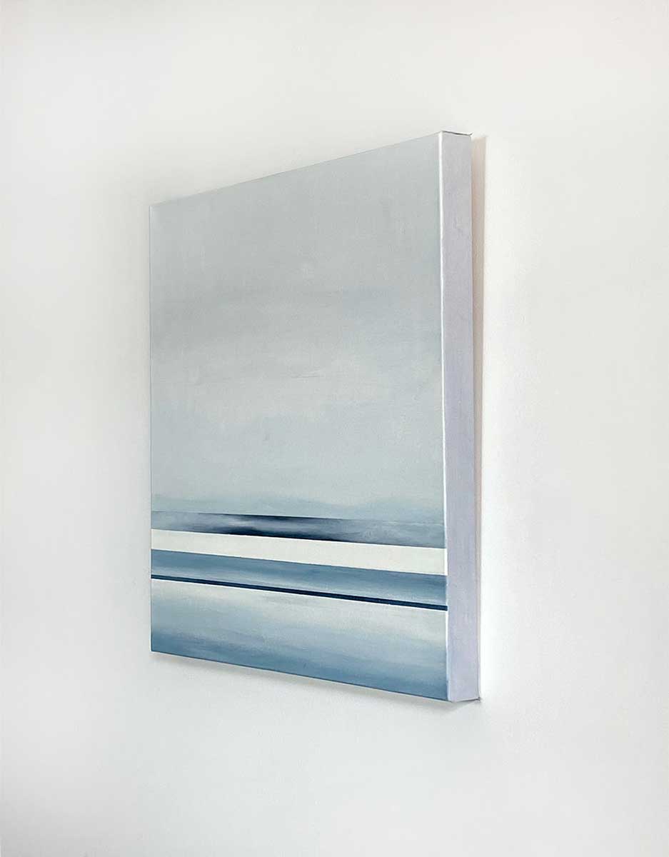  Side-angle view of an abstract painting featuring dark blue and white horizontal lines below a grey blended color block hangs on a white wall.
