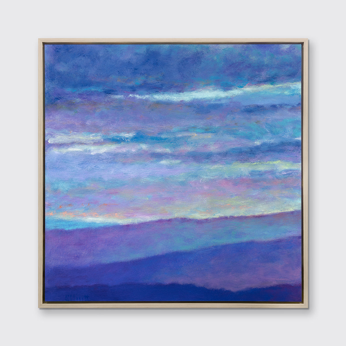 A blue, purple and light yellow abstract landscape print in a white oak wood floater frame hangs on a white wall.