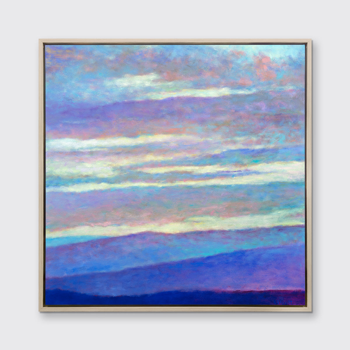 A blue, purple and light yellow abstract landscape print in a white oak floater frame hangs on a white wall.