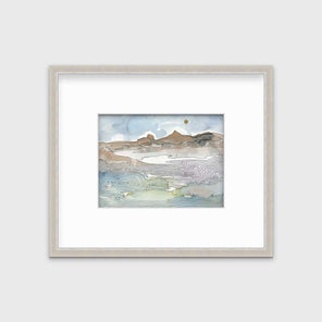 A blue, brown and light green abstract landscape print in a silver frame with a mat hangs on a white wall.