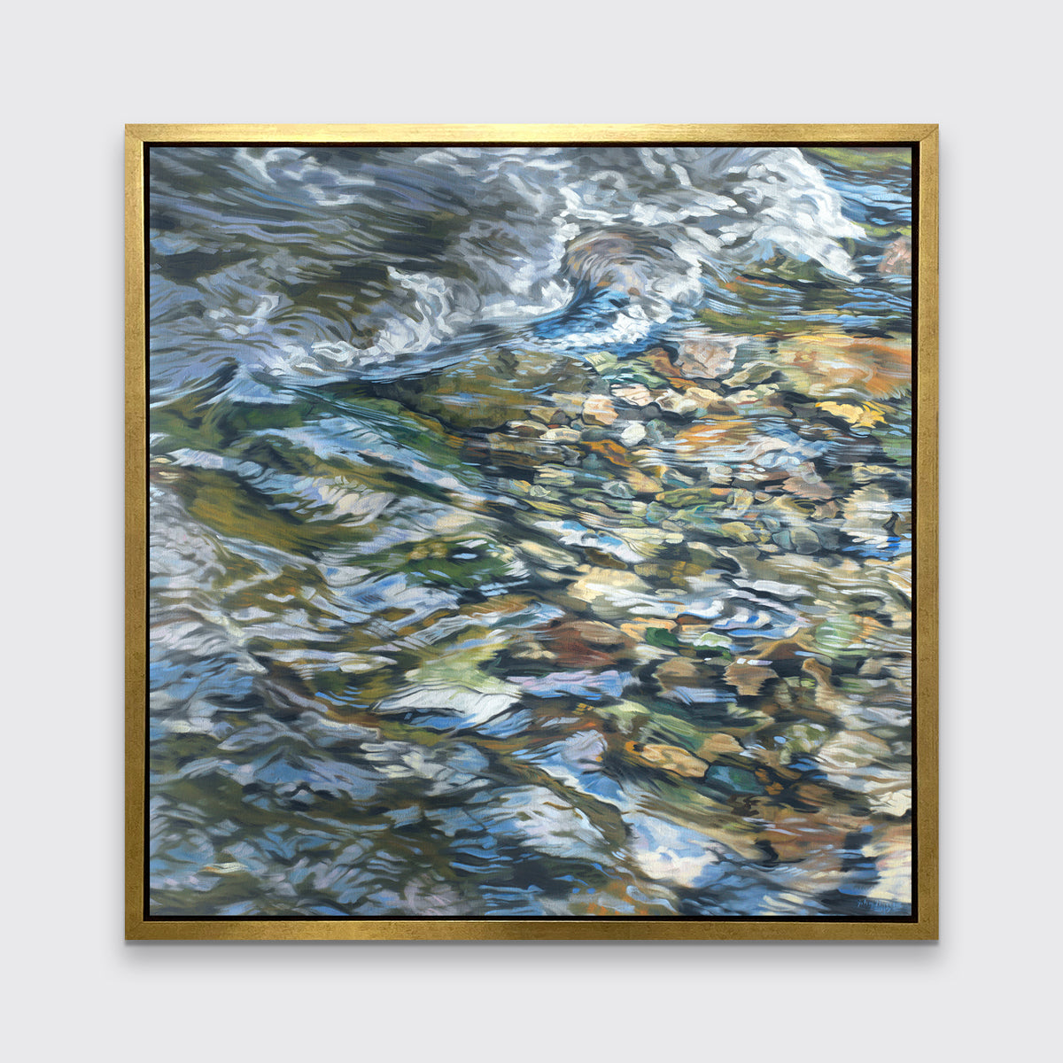 An abstracted riverbed print in a gold floater frame hangs on a white wall.