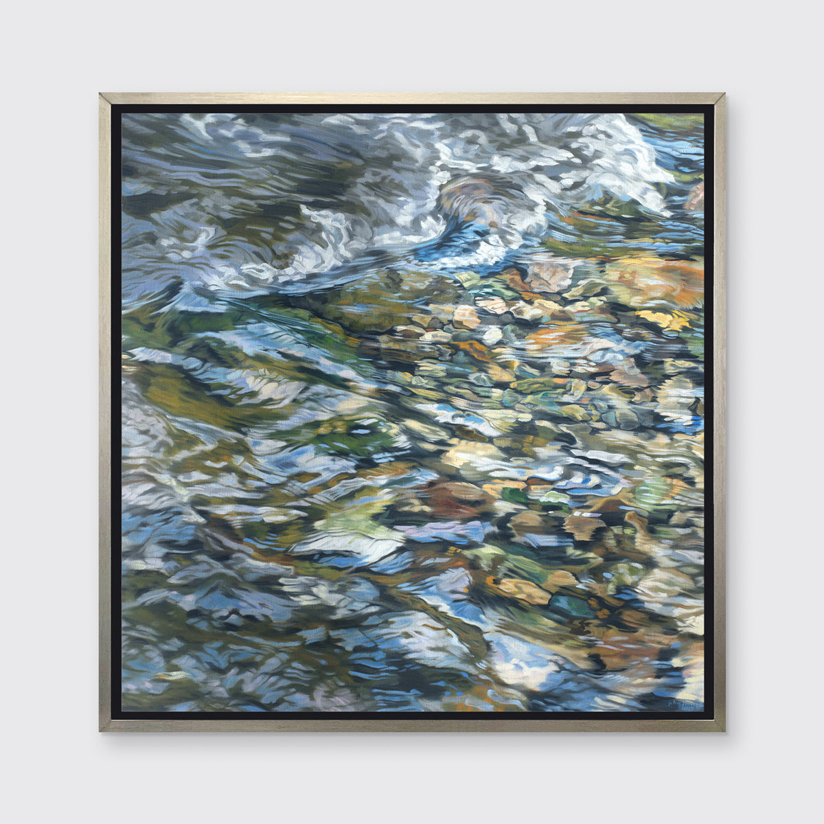 An abstract river bed print in a silver floater frame hangs on a white wall.