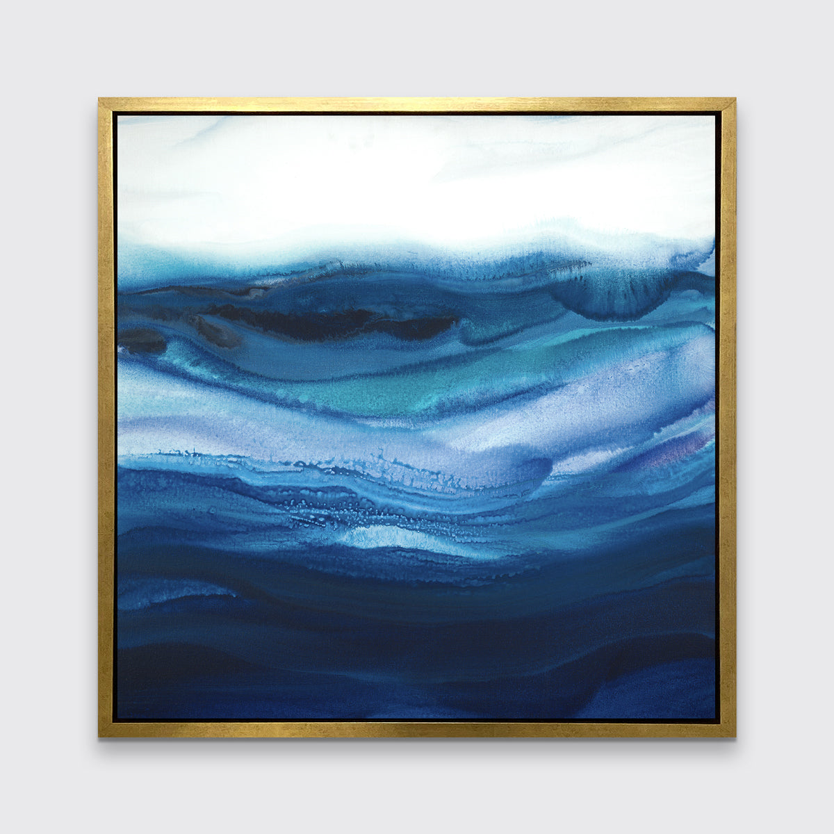 A blue, teal and white abstract print in a gold floater frame hangs on a white wall.