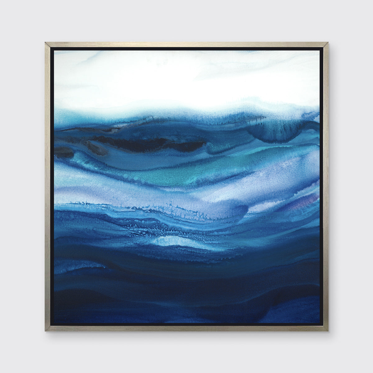 A blue, teal and white abstract print in a silver floater frame hangs on a white wall.