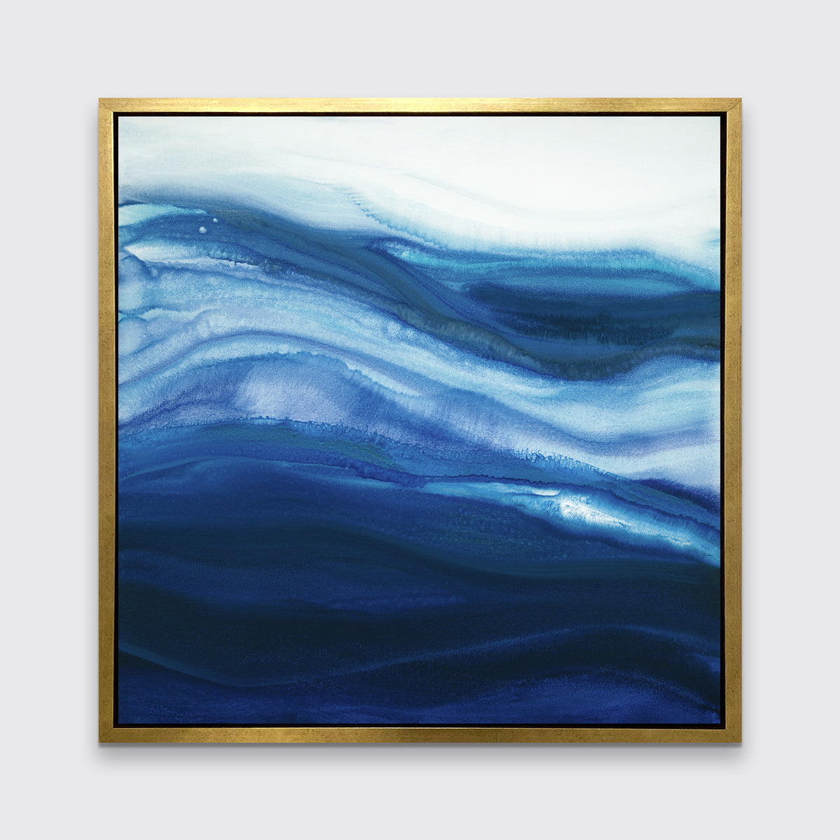 A blue, teal and white abstract print in a gold floater frame hangs on a white wall.