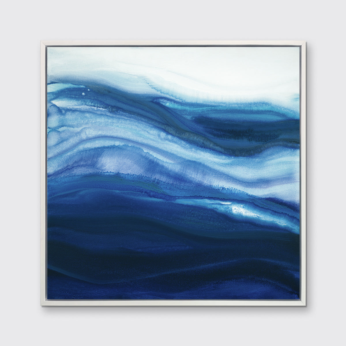 A blue, teal and white abstract print in a white floater frame hangs on a white wall.
