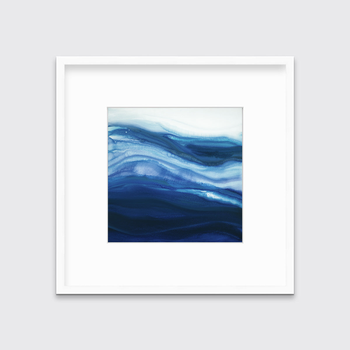 A blue, teal and white abstract print in a white frame with a mat hangs on a white wall.
