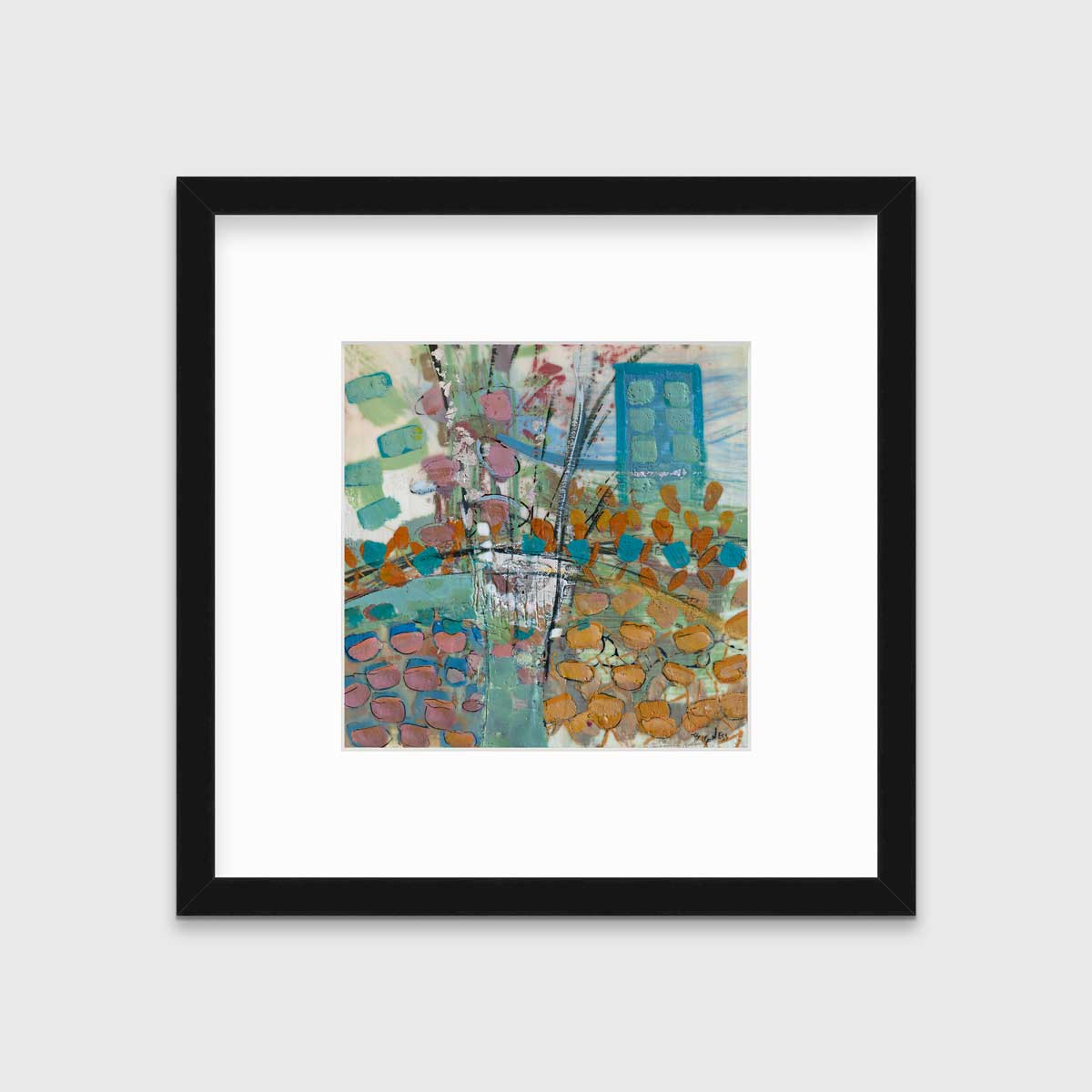 A multicolored abstract print, matted and framed in a black frame hangs on a white wall.