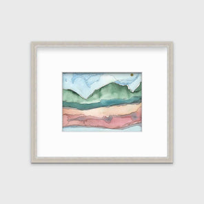 A blue, green and red abstract landscape print in a silver frame with a mat hangs on a white wall.