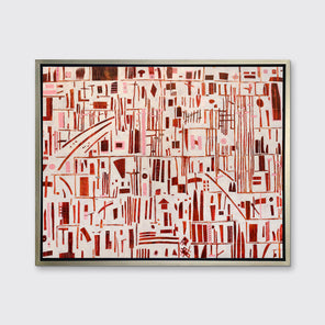 A red, pink and white abstract print in a silver floater frame hangs on a white wall.
