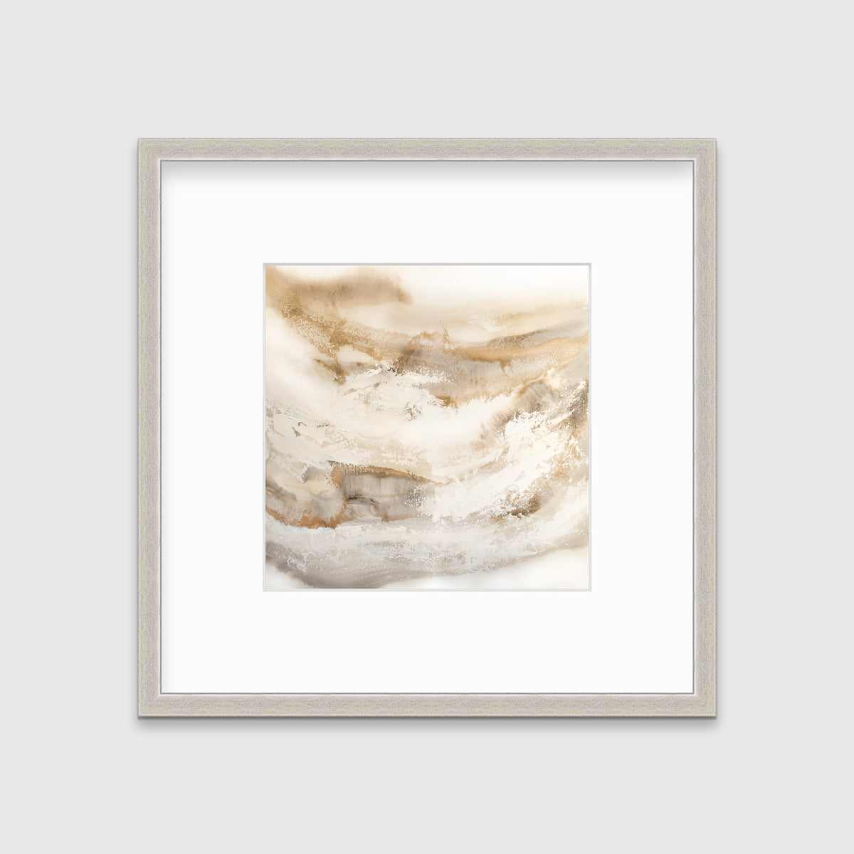 A gold, silver, white and beige abstract print in a silver frame with a mat hangs on a white wall.