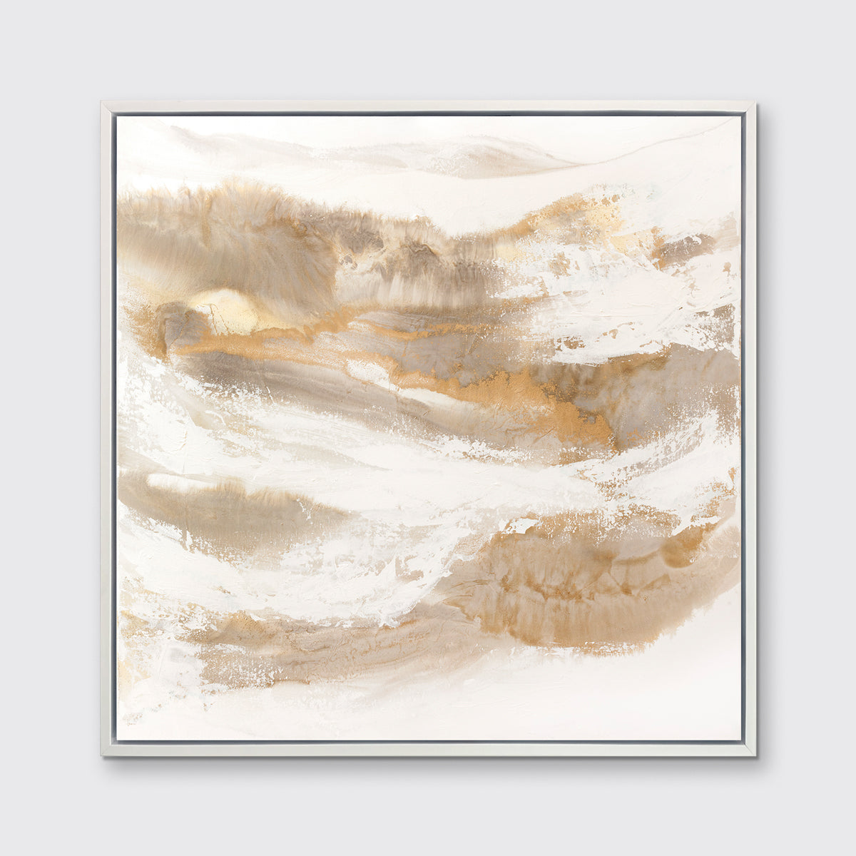A gold, silver, white and beige abstract print in a white floater frame hangs on a white wall.