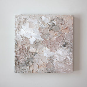 A painting is hanging on a wall. Its surface is decorated with white, pink and grey paint in a thick impasto. Wired and ready to hang.