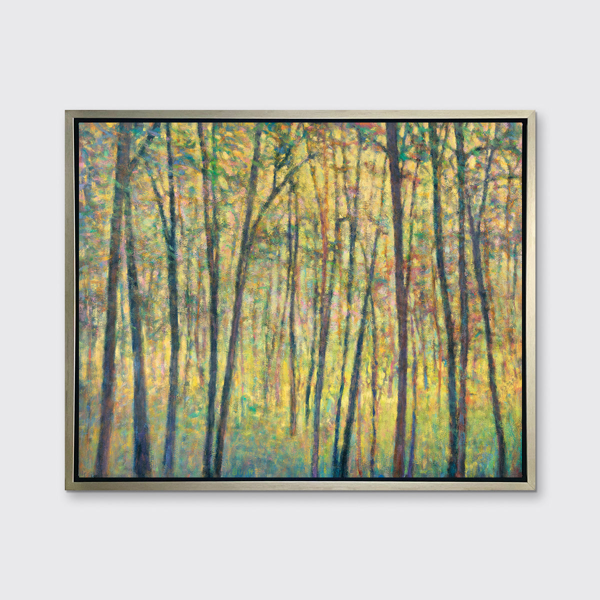 A yellow, brown and green abstract tree landscape print in a silver floater frame hangs on a white wall.