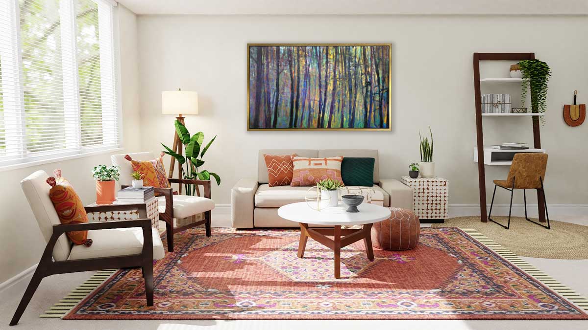 A multicolored abstract tree landscape print in a gold floater frame hangs on a white wall above a oversized white sofa with printed pillows, a white round coffee table and two white chairs.