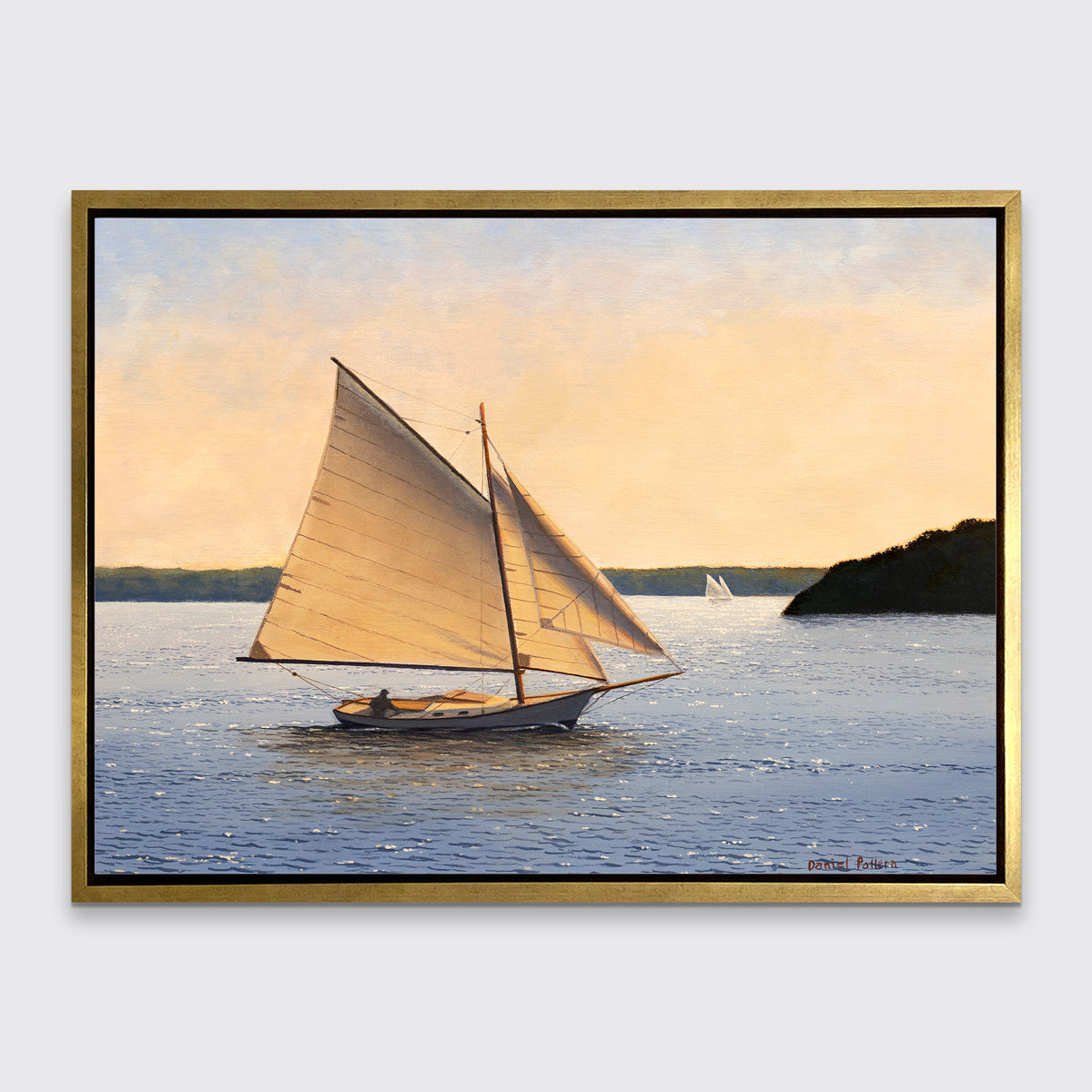 A blue, beige and green seascape print with sailboats in a gold floater frame hangs on a white wall.