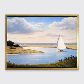 A print of a sailboat going down a winding blue river in a gold floater frame hangs on a white wall.