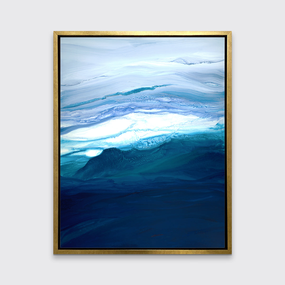 A blue, teal, lavender and white abstract print in a gold floater frame hangs on a white wall.