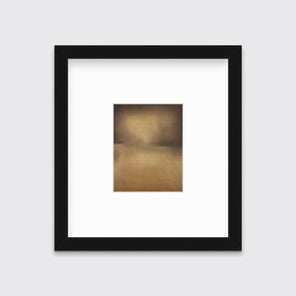 A brown and gold abstract print in a black frame with a mat hangs on a white wall.