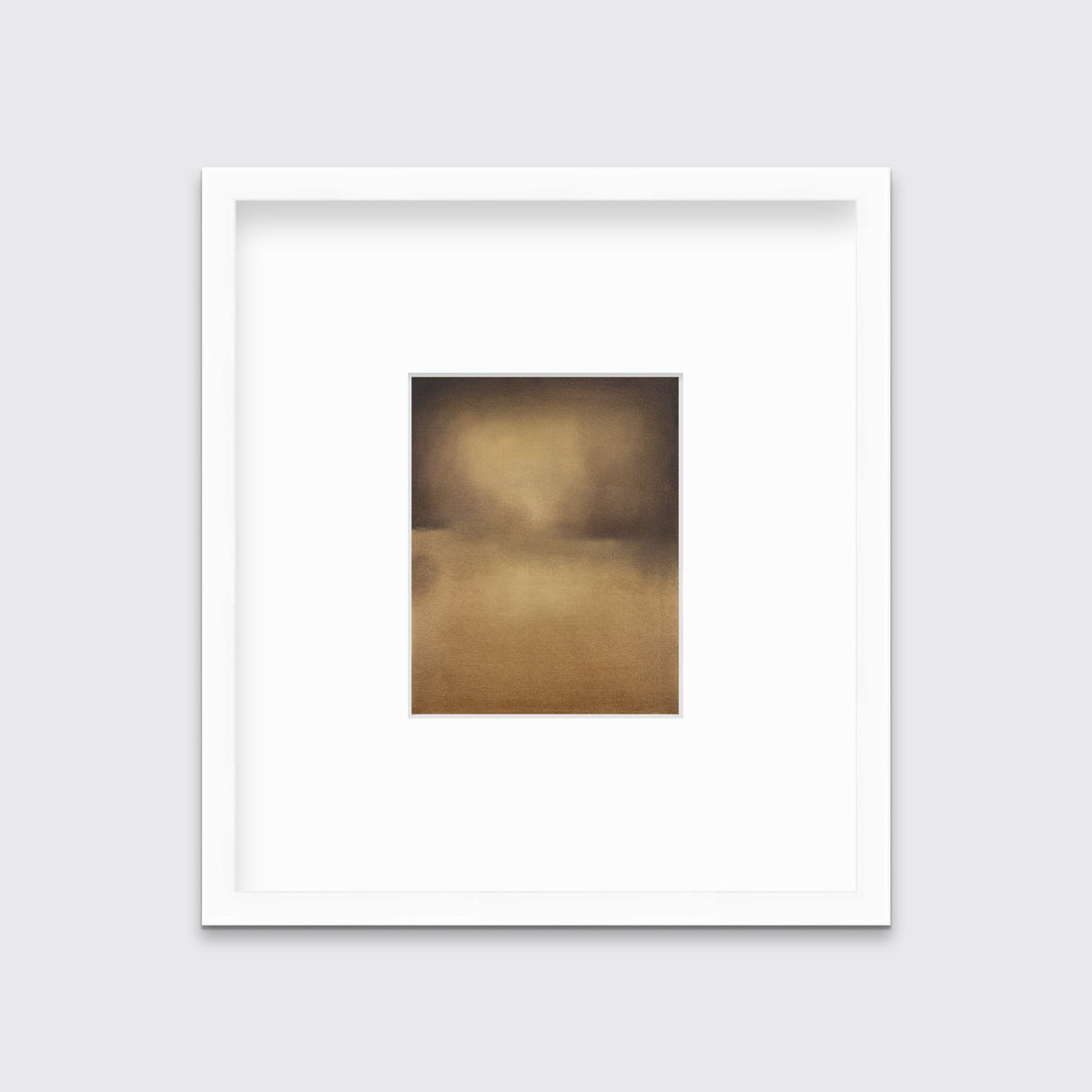 A brown and gold abstract print in a white frame with a mat hangs on a white wall.
