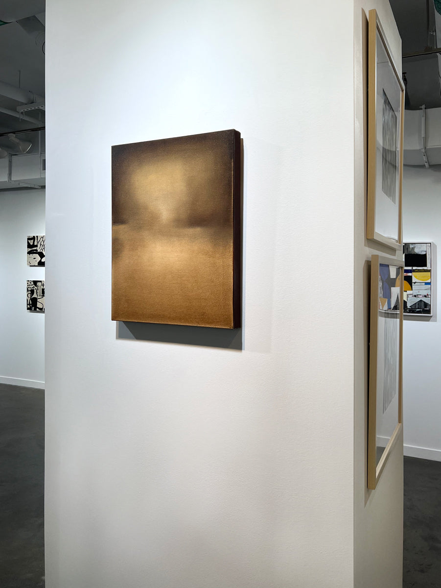 A right side-view of a brown, beige and goldenrod abstract painting by Tony Iadicicco hangs on a white wall.