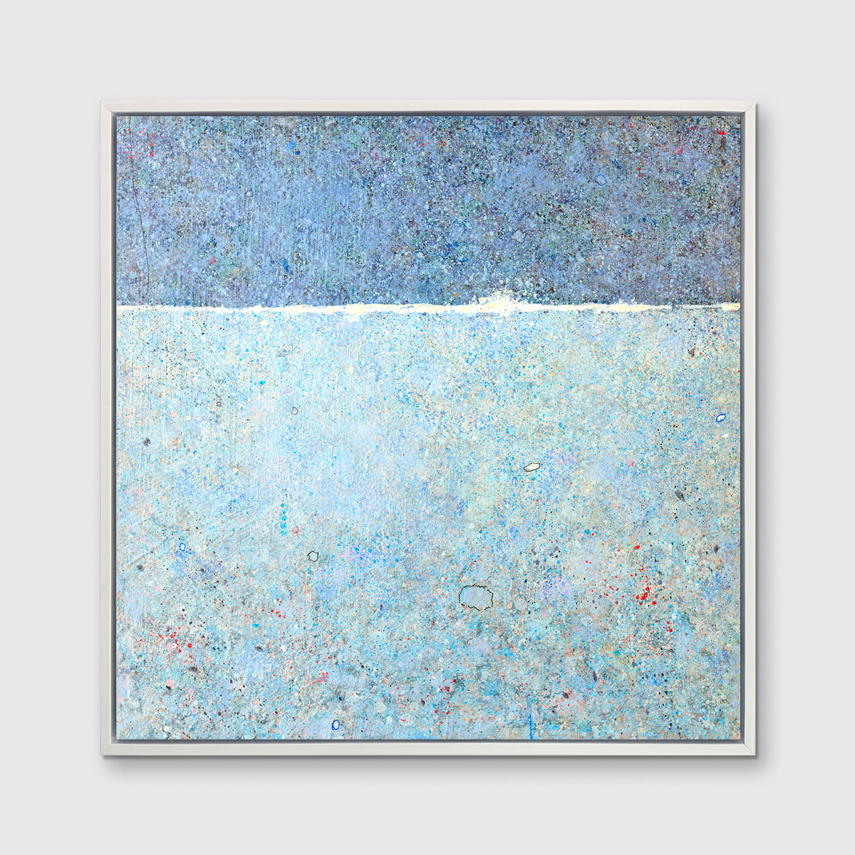 A blue abstract landscape in a white floater frame hangs on a white wall.