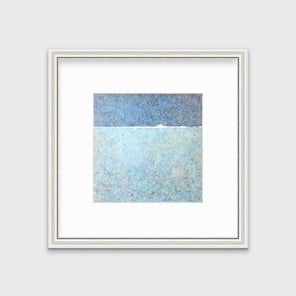 A blue abstract landscape print in a silver frame with antiqued beading with a mat hangs on a white wall.