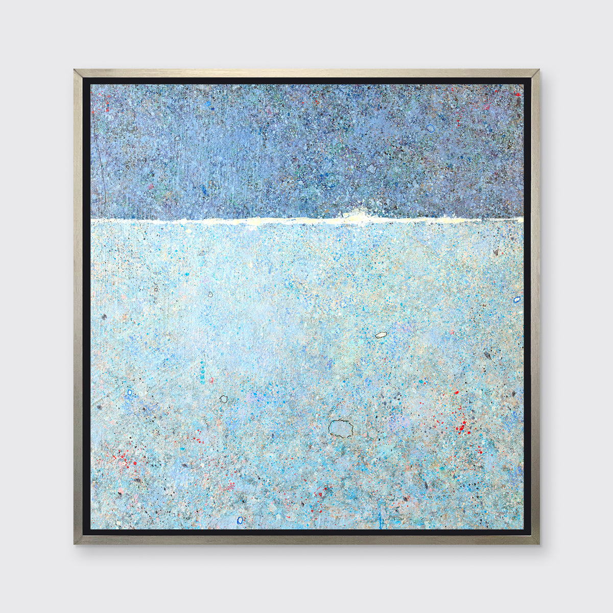 A blue abstract landscape in a silver floater frame hangs on a white wall.