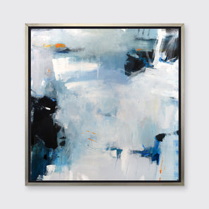 A blue and grey abstract print in a silver floater frame hangs on a white wall.