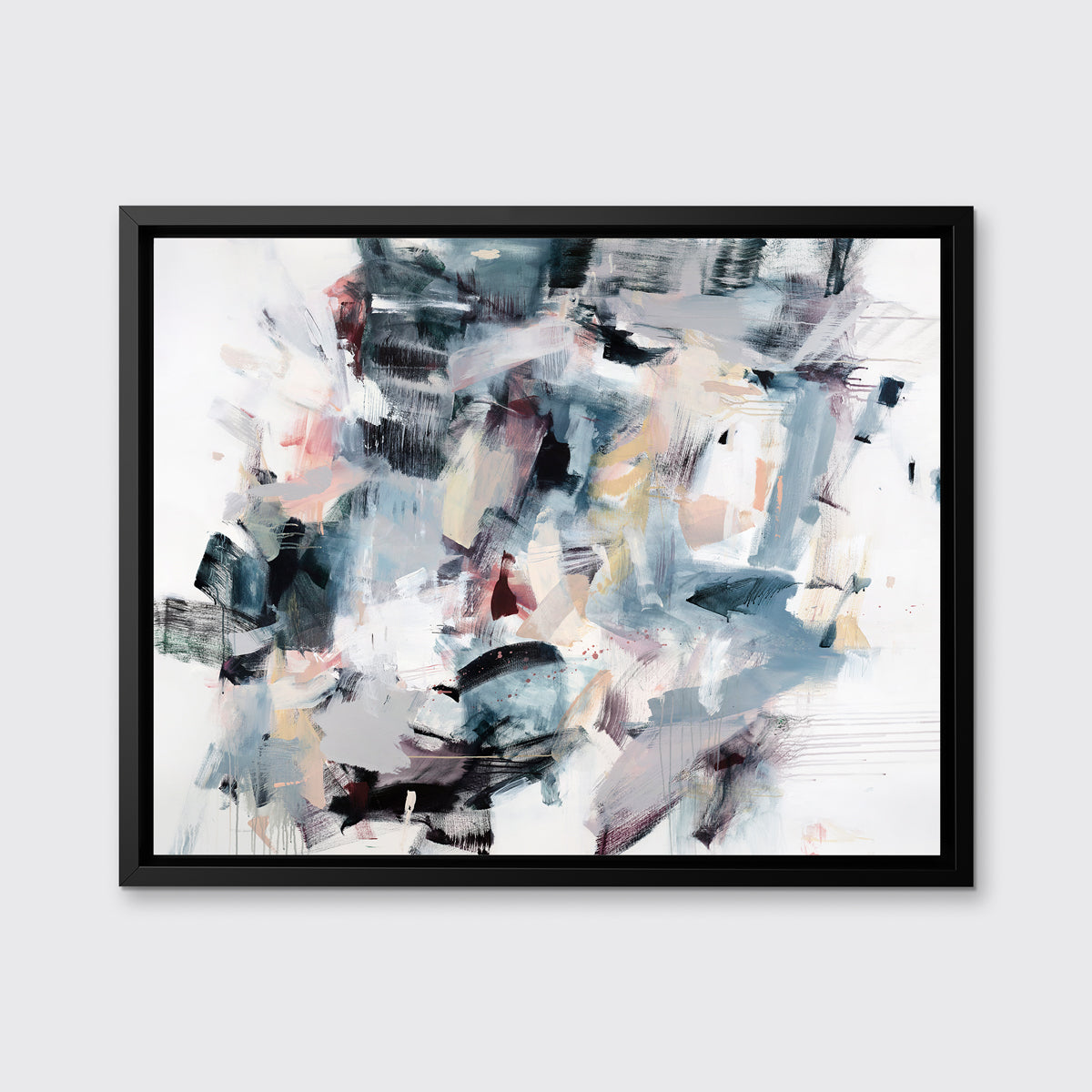 A multicolored abstract print in a black floater frame hangs on a white wall.