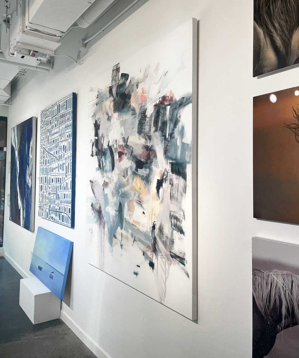 Multi-colored cool toned abstract painting by Kelly Rossetti hangs on a white wall in the gallery, viewed from the right. 