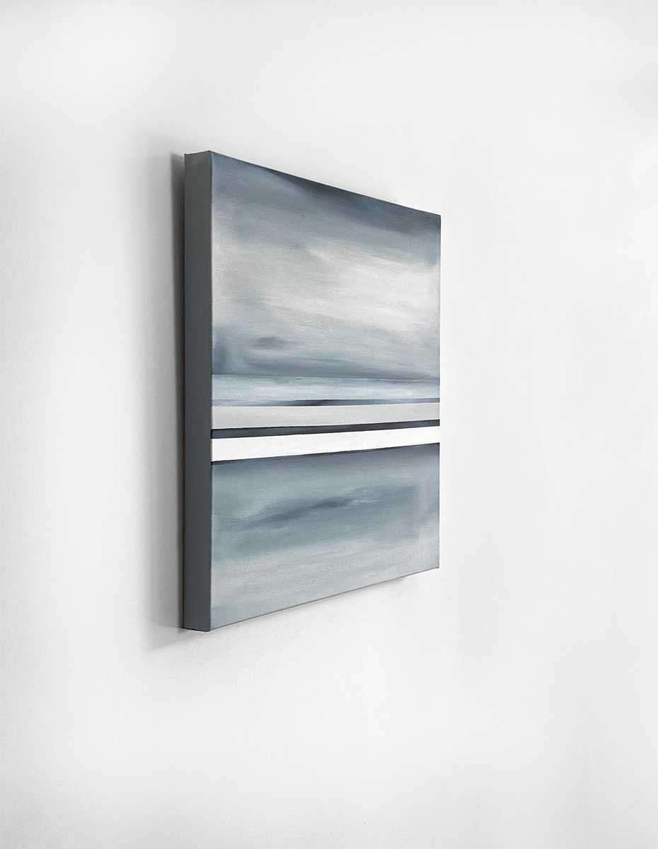 Side-angle view of an abstract painting with dark blue, white and grey horizontal lines hung on a white wall.
