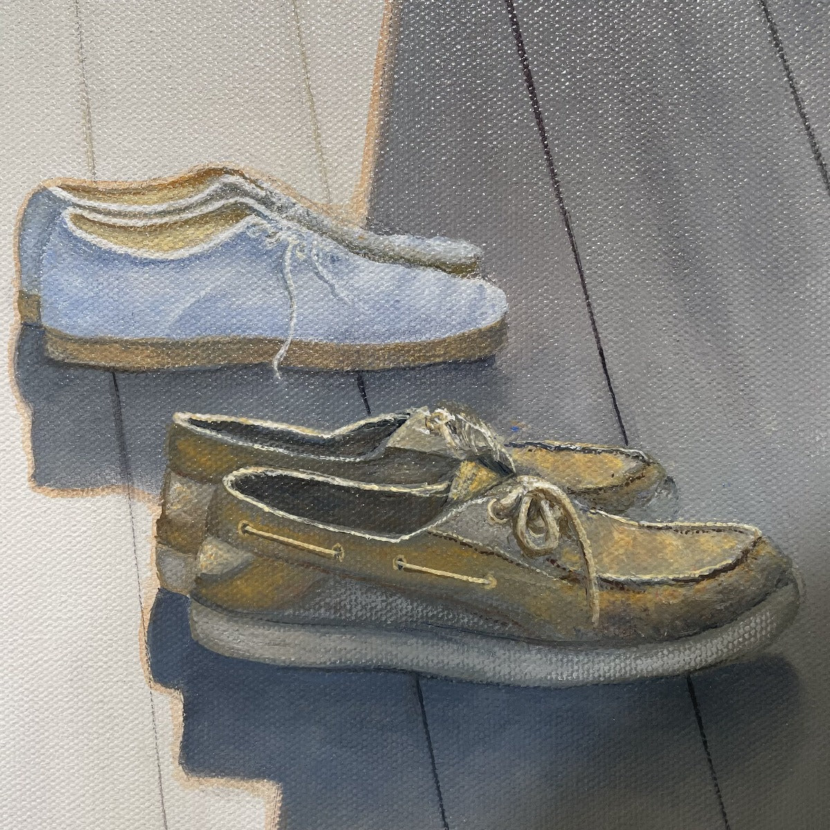 A close up view of both pairs of shoes, one set is a pair of white tennis shoes and the other is a pair of brown loafers.