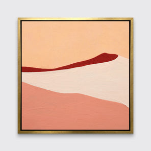 A red, peach and beige abstract print in a gold floater frame hangs on a white wall.