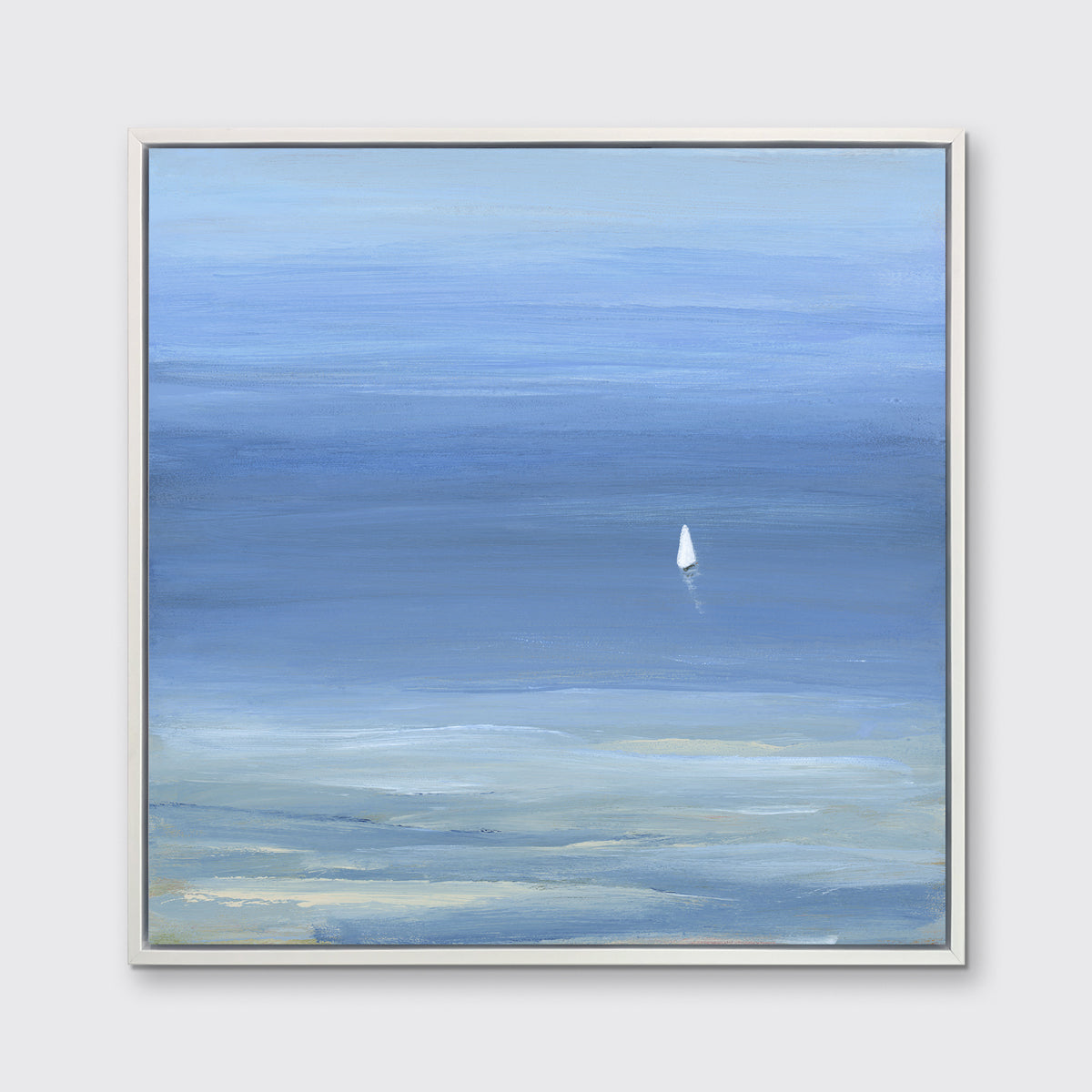 A blue, light green and white abstract seascape print with a small sailboat in a white floater frame hangs on a white wall.