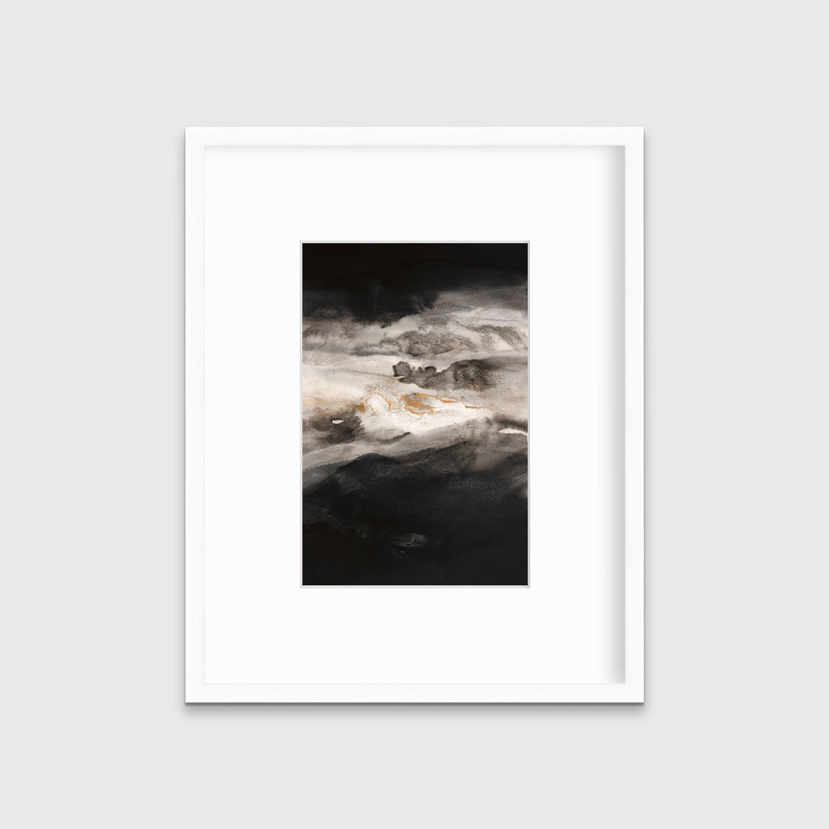 A black, white, beige and gold abstract print in a white frame with a mat hangs on a white wall.
