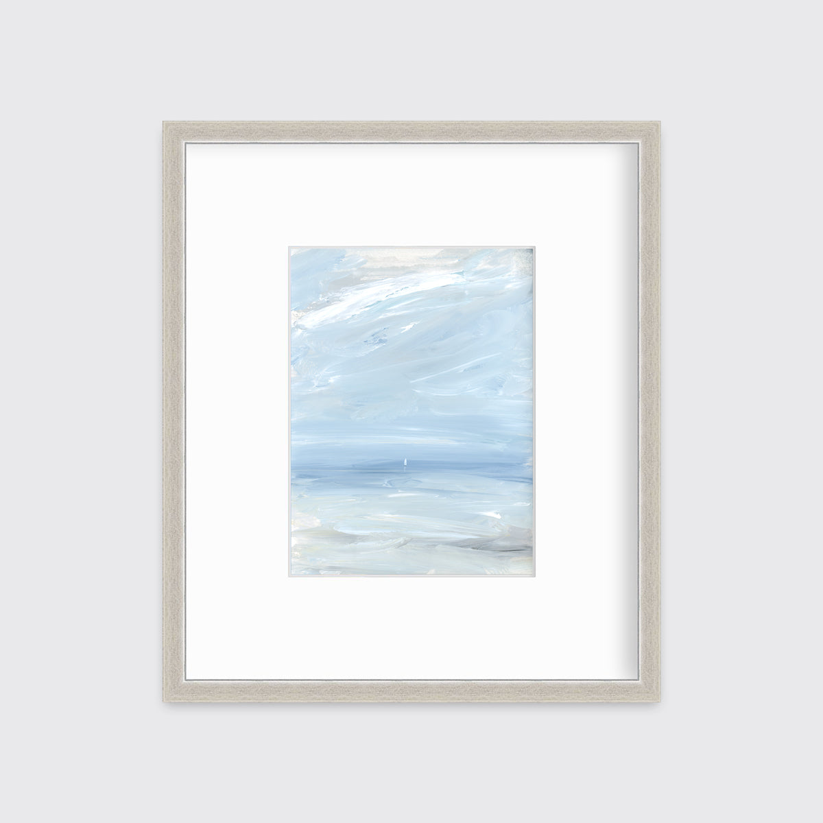 A white, blue and grey abstract seascape print in a silver frame with a mat hangs on a white wall.