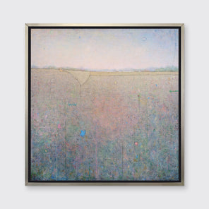A green, pink and blue abstract landscape print in a silver floater frame hangs on a white wall.