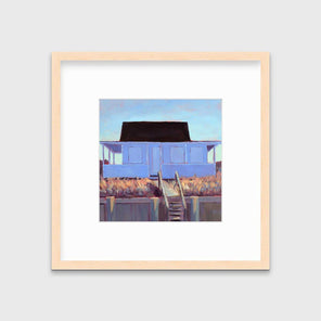 A light blue, lavender, burnt orange and brown contemporary cottage print in a natural wood frame with a frame hangs on a white wall.