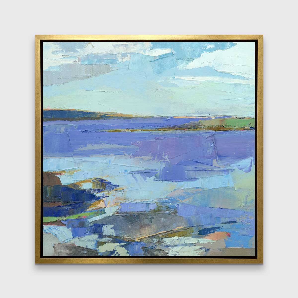 A blue, purple, white and green abstract landscape print in a gold floater frame hangs on a white wall.