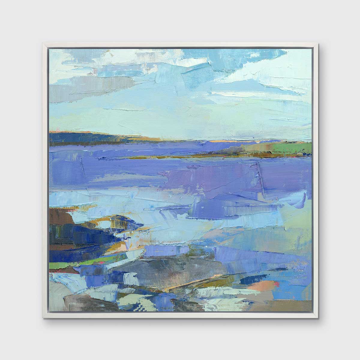 A blue, purple, white and green abstract landscape print in a white floater frame hangs on a white wall.