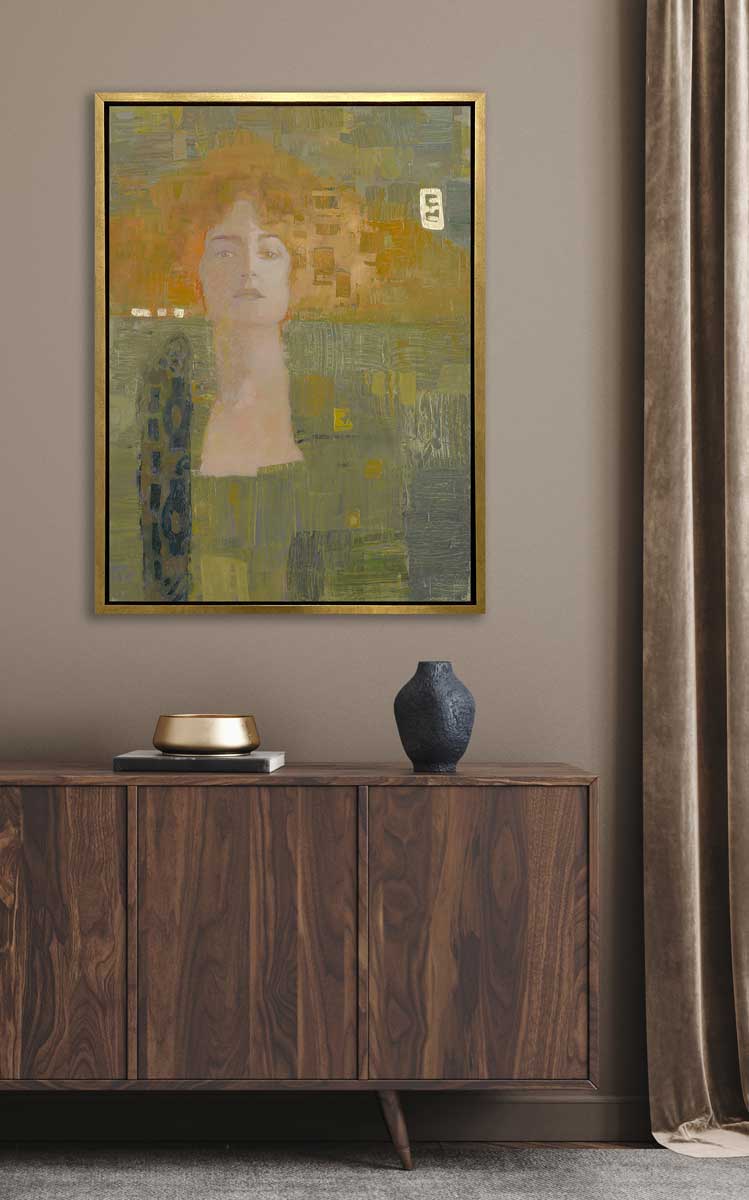 A orange and olive green abstract print of a woman in a gold floater frame hangs on a beige wall above a wooden sideboard with a black vase and a book with a gold decorative bowl.