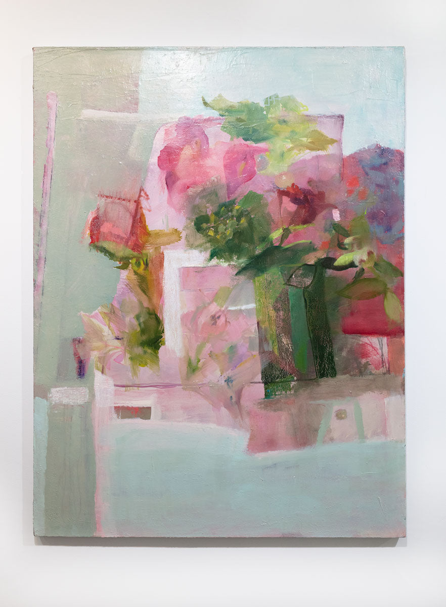A painting depicts a green vase full of lush, pink roses and peonies. The painting is hung on a gallery wall. This painting is wired and ready to hang.
